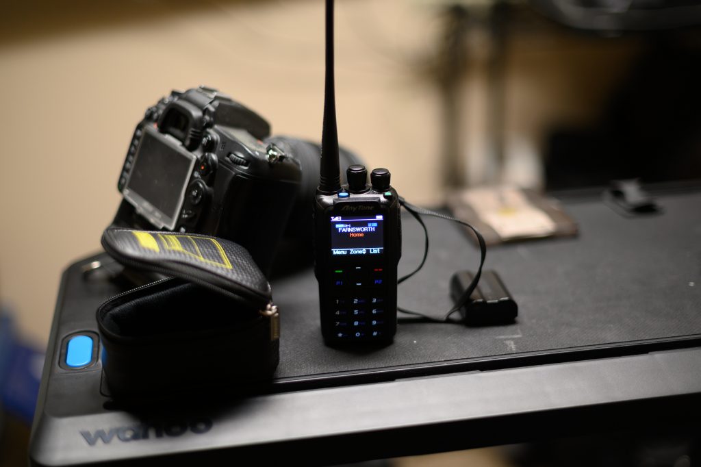 Photo of a handheld amateur radio unit and a Nikon DSLR