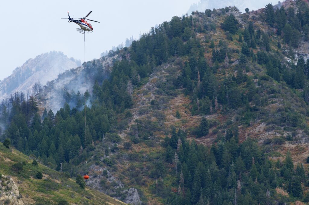 An aerial firefighting helicopter, N357TA, flies over the Neff's Fire in Neff's Canyon just east of Millcreek, Utah.