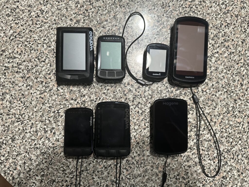 A photo of 7 different GPS bike computers on a counter.
